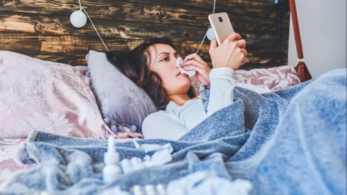 women with smartphone sick in bed women with smartphone sick in bed