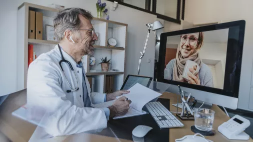 Mann und Frau Arzt mit Patient am Computer im Gespräch Praxis Mann und Frau Arzt mit Patient am Computer im Gespräch Praxis